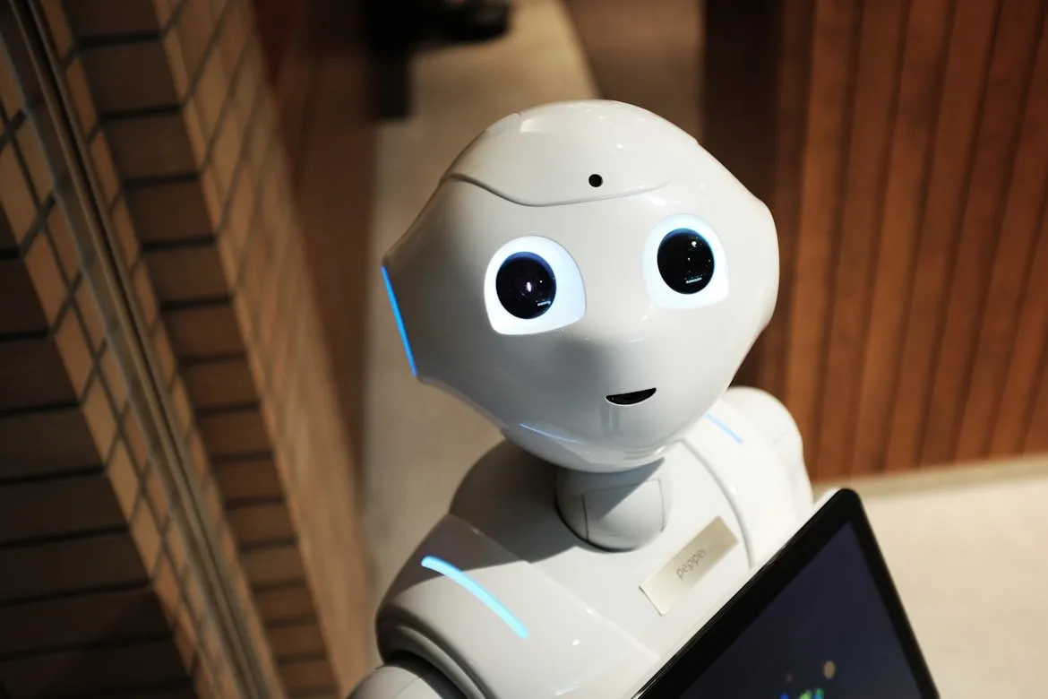White humanoid robot standing near a textured brown wall, representing the wave of AI model launches and features shipping in March 2026