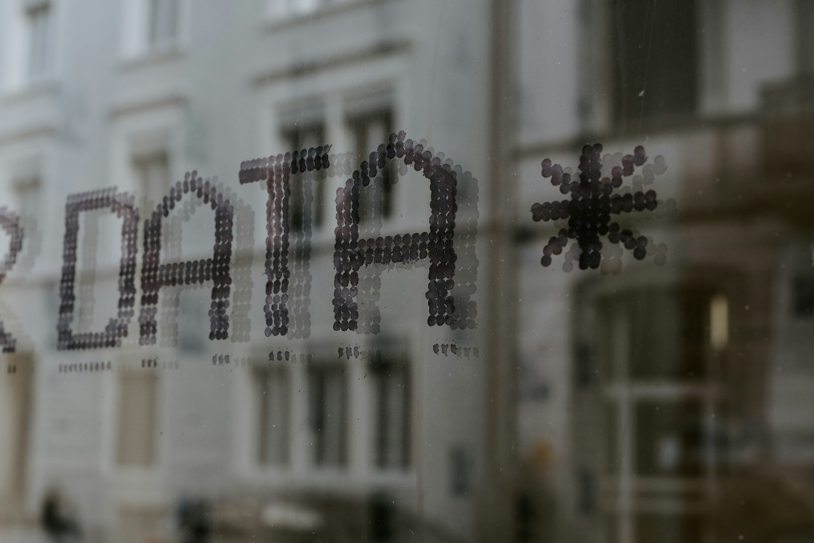 Close-up of a glass office window with a corporate building reflected in the background, evoking the opaque trust boundaries between AI vendors and client financial data